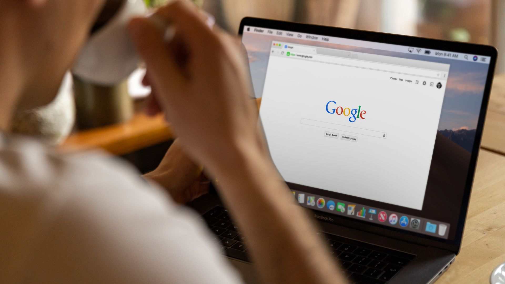 A person browsing Google search results on a laptop, illustrating AI-generated overviews and content optimization for AI summaries in search engines.
